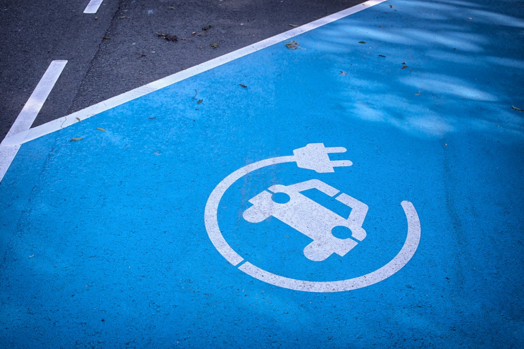 Logo 'charge your car here' on blue parking lot