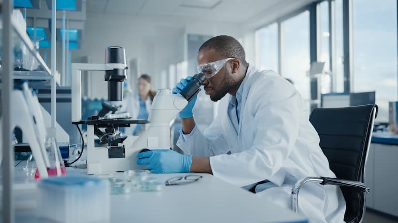 Medical scientist using microscope