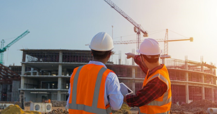 Construction site workers looking at a crane