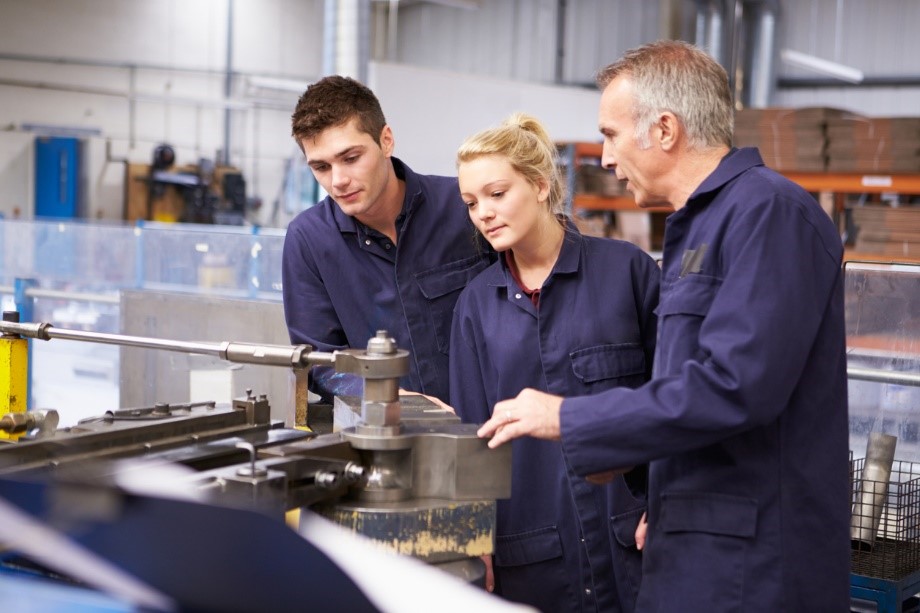 Manufacturing engineers being tutored by a senior team member