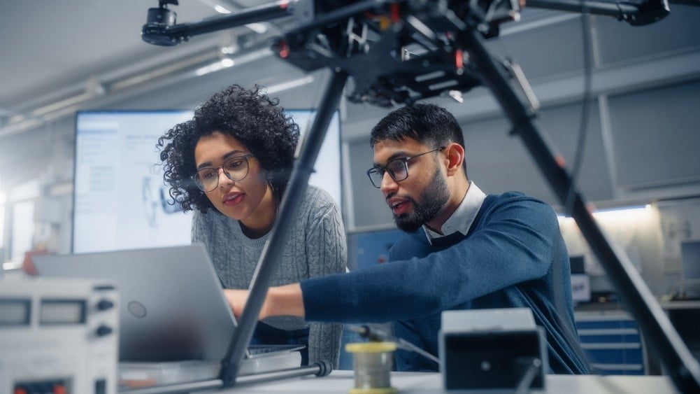 Two engineers looking at spring manufacturing on a computer