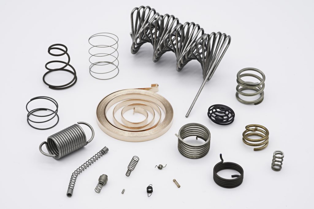 An array of different metal springs with a white background
