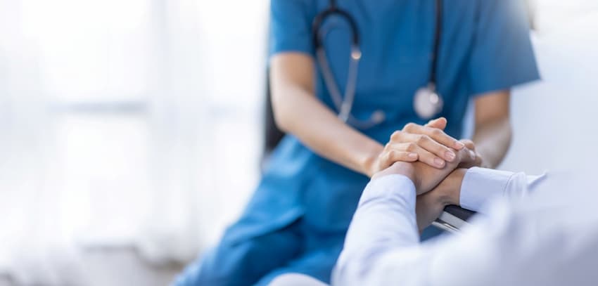 A doctor holding a patient's hand