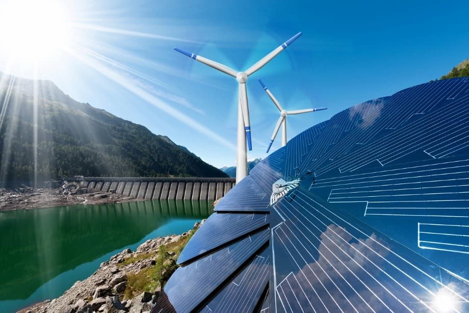 Solar panels and windmills in front of a dam