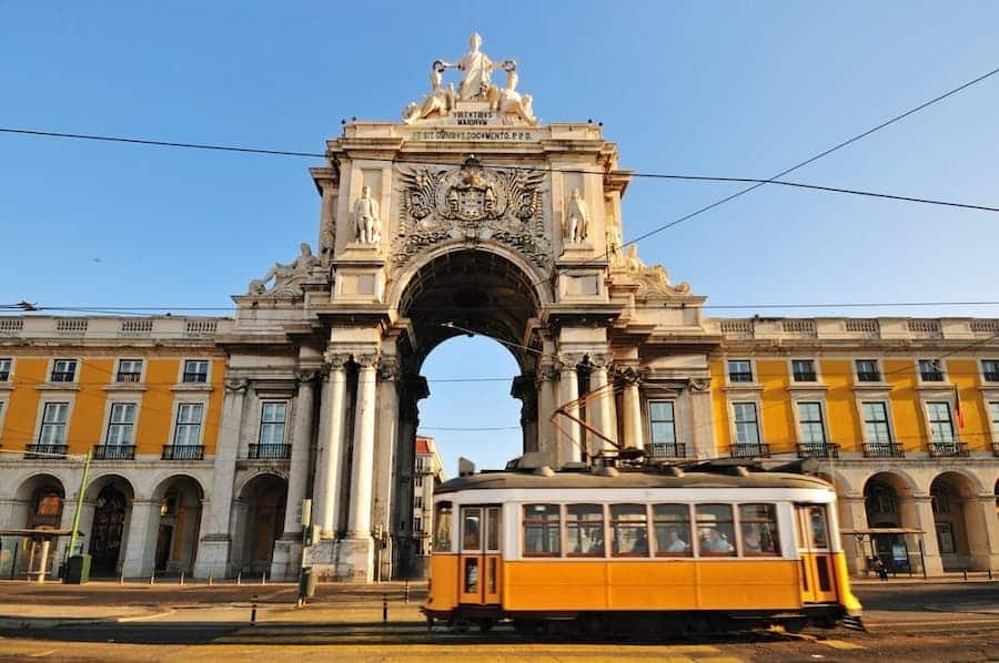 A yellow tram in front of Praça do Comércio