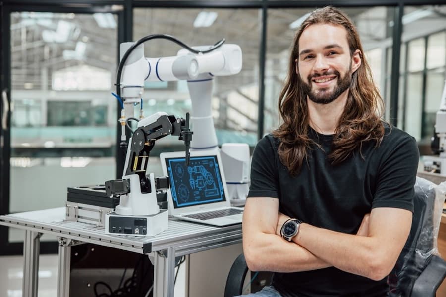 A person with arms crossed in front of a machine